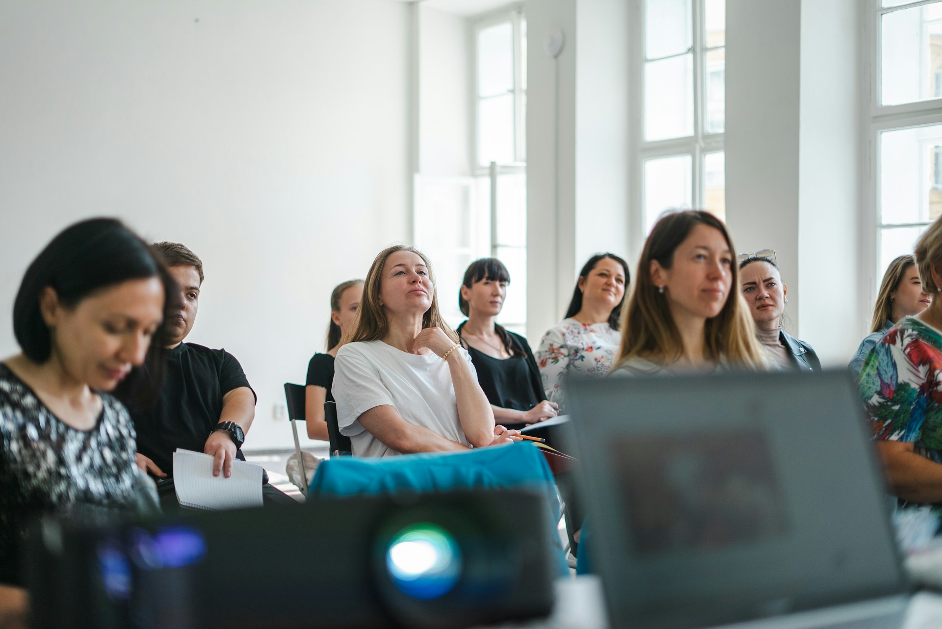 Several adults seated in a classroom, looking forward towards an unseen speaker